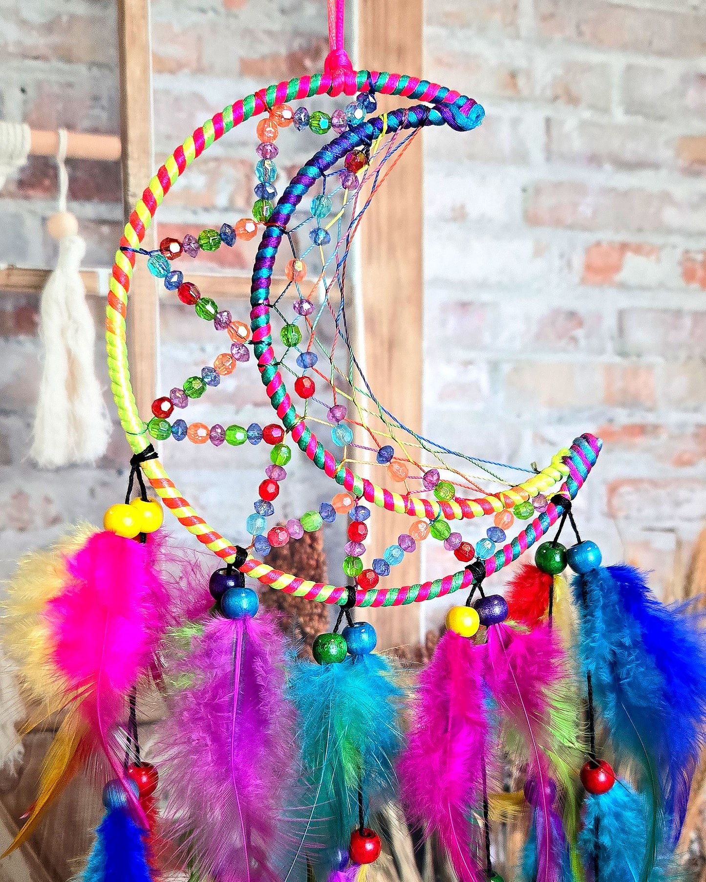 close up of multi color crescent moon feather dream catcher