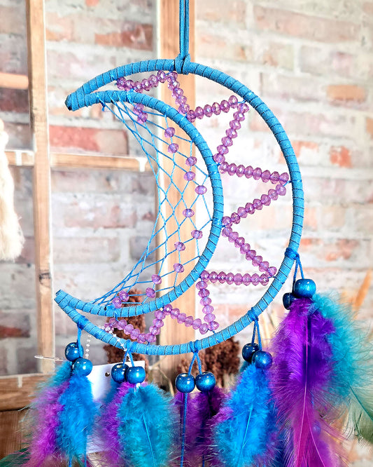 close up of blue and purple crescent moon dream catcher with feathers