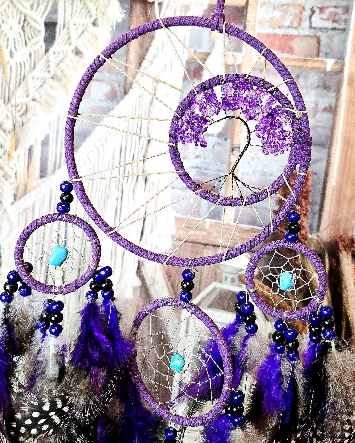 close up of purple tree of life dream catcher with feathers