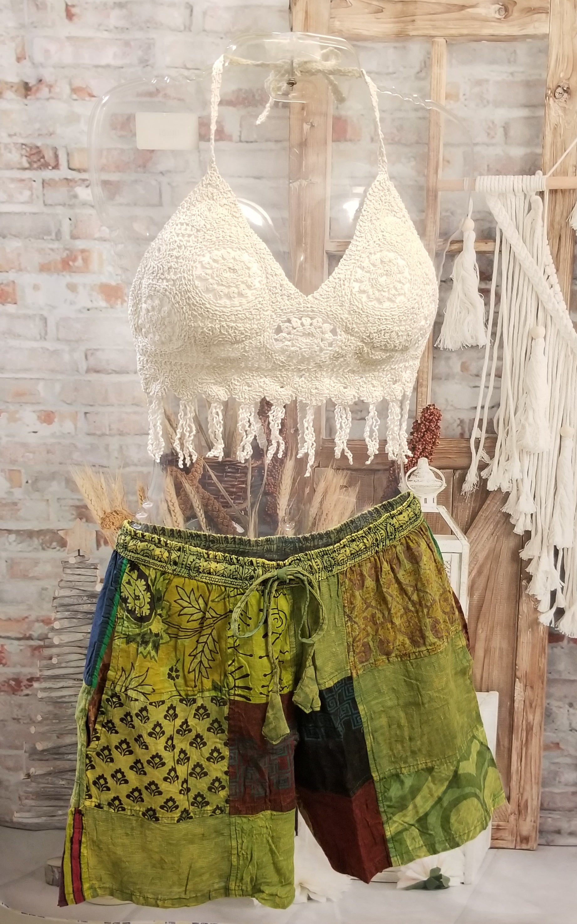 short crochet halter top with fringe shown with green patchwork shorts