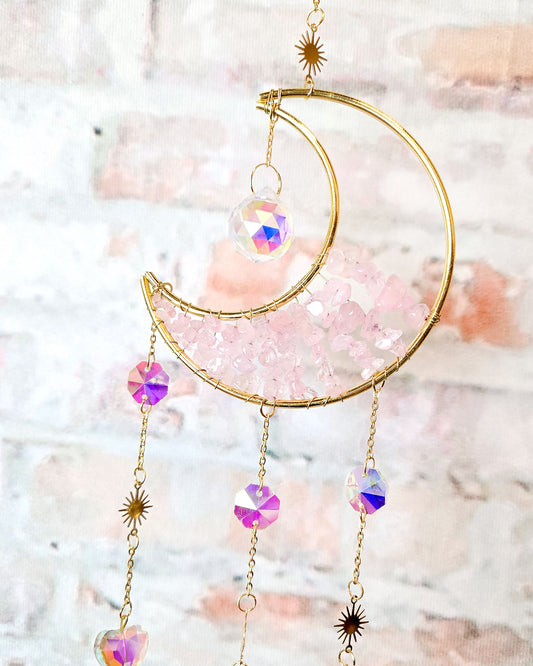 close up of crescent moon crystal suncatcher with rose quartz stones for boho hippie home décor