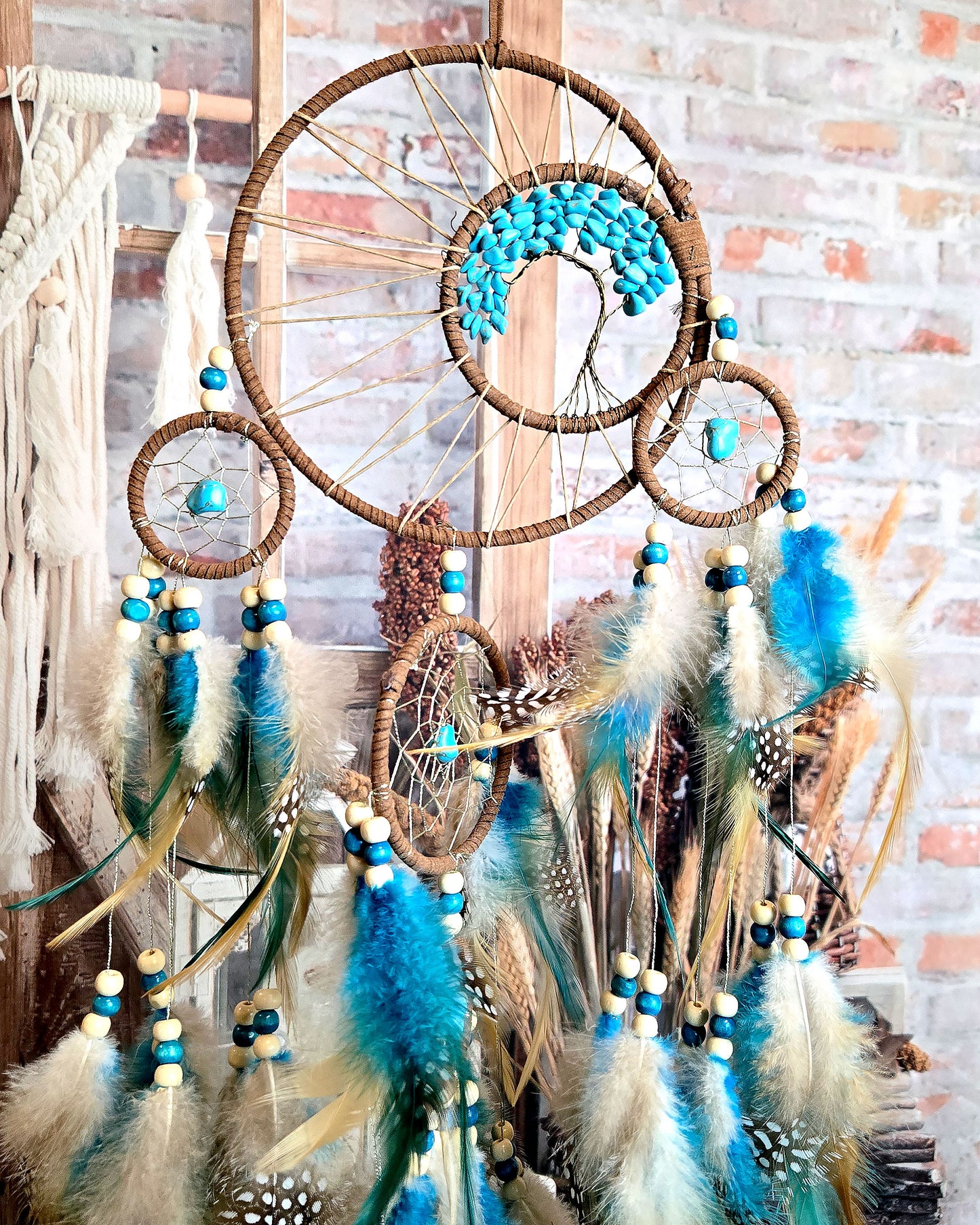 close up of teal and brown tree of life dream catcher with feathers