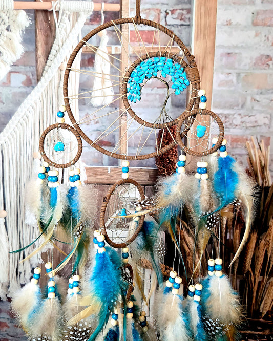 teal and brown tree of life dream catcher with feathers close up