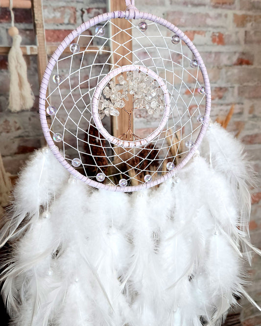 light purple and white tree of life dream catcher with feathers close up